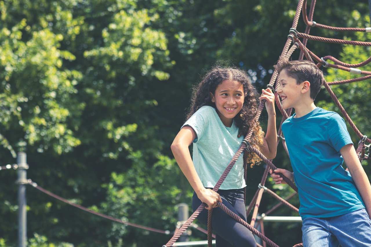 Teens playing on climbing frame